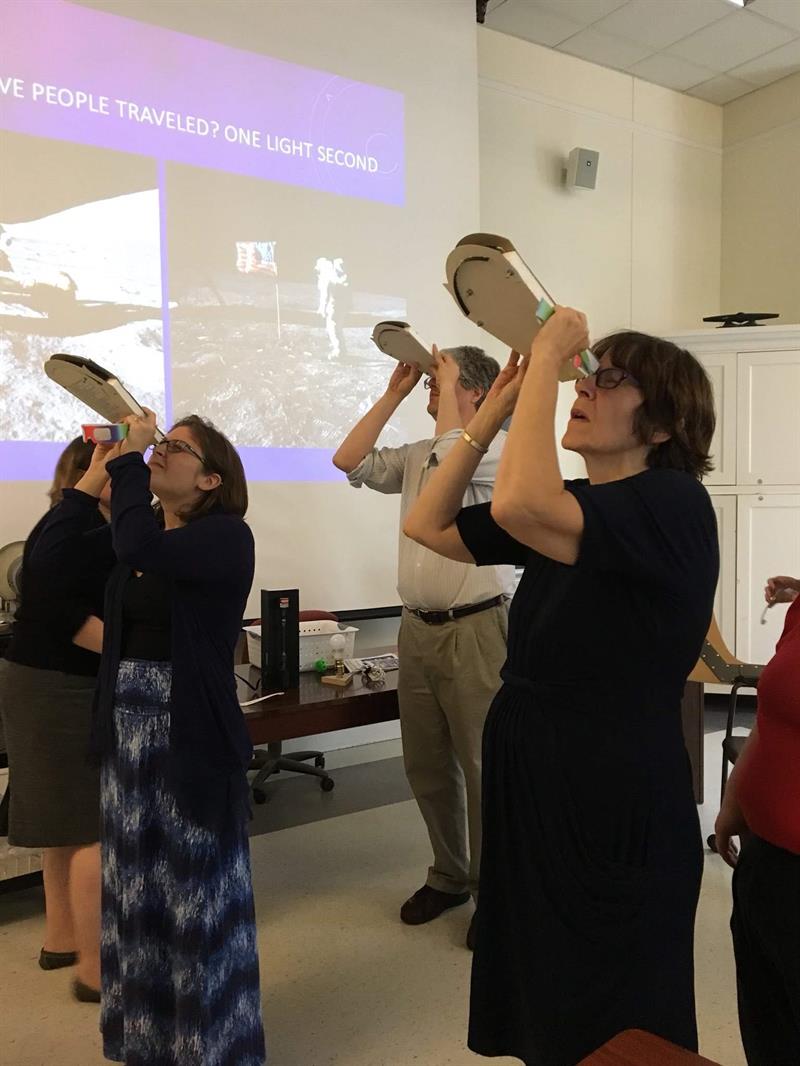 Teachers and UD Faculty are gazing at prisms during an astronomy seminar.